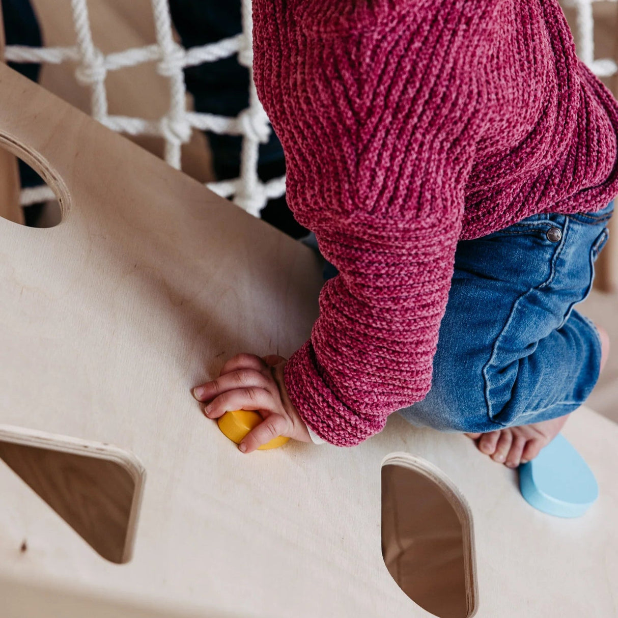 Detaljbild på färgglada klättergrepp på Cliff klättervägg