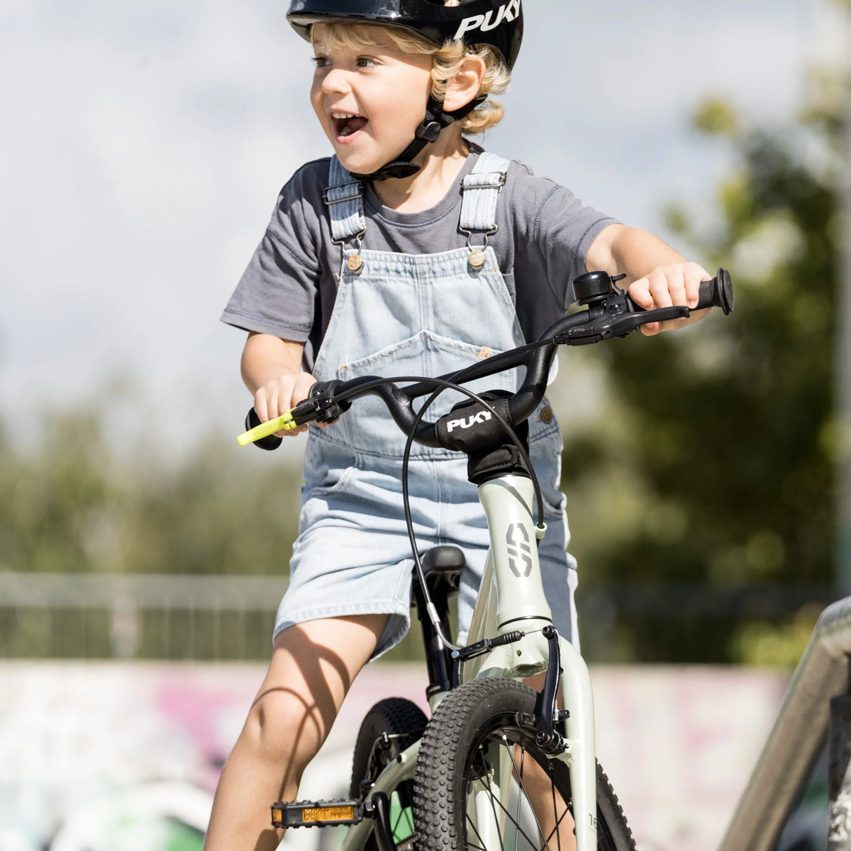 Barn som cyklar på Puky LS-PRO 14 i mintgrön med hjälm