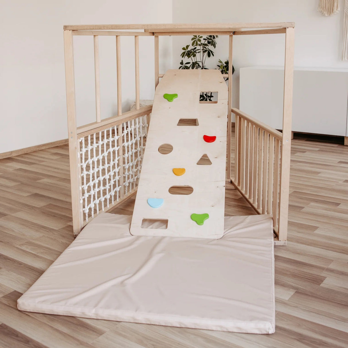 Cliff climbing wall in birch wood with colorful grips for children