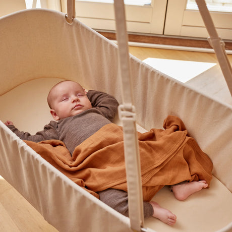 Bebis som ligger och sover i vagga på stativ med vaggmotor från Membantu